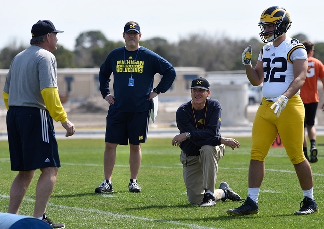 FILE - In this Feb. 29, 2016, file photo, Michigan's head coach Jim Harbaugh, center right, watches defensive coordinator Don Brown, left, work with Cheyenn Robertson during team practice in Brade ...