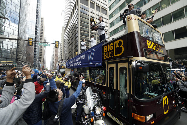 Villanova's Ryan Arcidiacono holds a trophy as he and his teammates take part in a parade celebrating their NCAA college basketball championship, Friday, April 8, 2016, in Philadelphia. Villanova ...