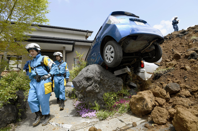 Police officers conduct a search operation at the site of a landslide caused by an earthquake in Minamiaso, Kumamoto prefecture, Japan, Sunday, April 17, 2016. Two nights of increasingly terrifyin ...