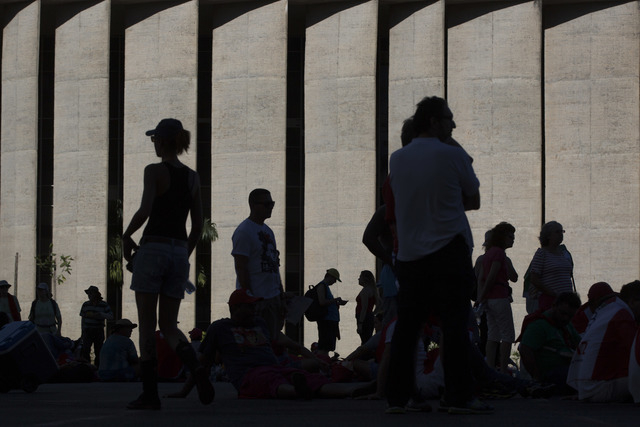 Pro-government demonstrators gather under the shade outside Congress, where lawmakers are voting on whether to impeach Brazil's President Dilma Rousseff, in Brasilia, Brazil, Sunday, April 17, 201 ...