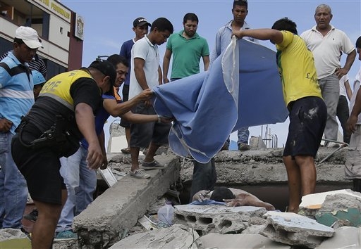 Volunteers cover a body trapped in a collapsed building, after a massive earthquake in Pedernales, Ecuador, Sunday, April 17, 2016. The strongest earthquake to hit Ecuador in decades flattened bui ...