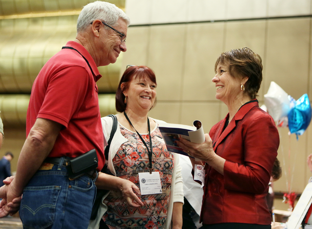 United States Senate candidate Sharron Angle, right, autographs her book for supporters Charles Milne, Jr., left, and his wife Linda at the Clark County Republican Party county convention at the R ...