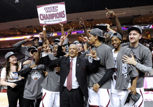 New Mexico State coach Marvin Menzies, center, celebrates with his team after defeating UT Arlington in the Western Athletic Conference tournament championship NCAA college basketball game, Saturd ...