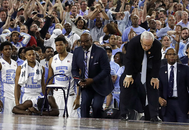 North Carolina head coach Roy Williams, right and his players on the bench react after the NCAA Final Four tournament college basketball championship game against Villanova, Monday, April 4, 2016, ...