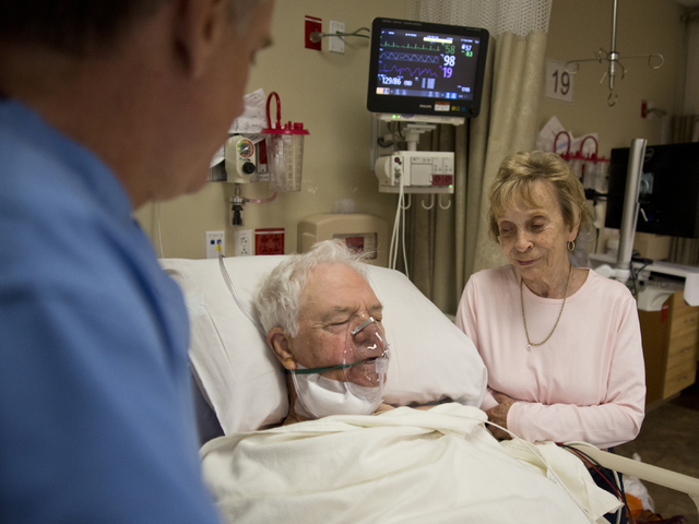 Don Fox, center, recovers from his surgery as his partner Ellie Campbell, right, and Dr. Frederick Goll  stand at his bedside at St. Rose Dominican Hospital's Siena Campus in Henderson on Friday,  ...