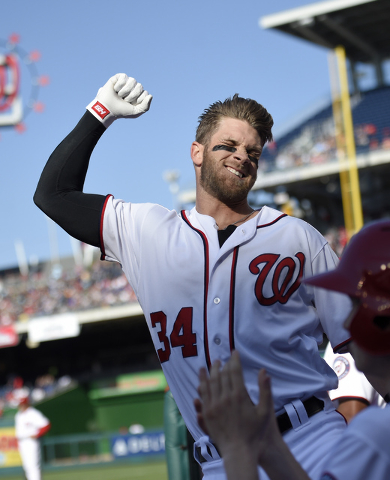 Washington Nationals' Bryce Harper pumps his fist as he takes a curtain call after he hit a grand slam during the third  inning of an baseball game against the Atlanta Braves, Thursday, April 14,  ...