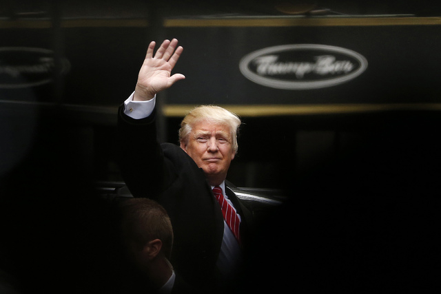 Donald Trump acknowledges supporters while leaving Trump Tower on his way to visit the World Trade Center Museum, Saturday, April 9, 2016, in New York. (AP Photo/Julio Cortez)