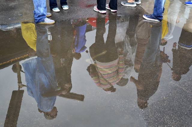 Festival goers are reflected in a puddle on a rainy afternoon during the Great Vegas Festival of Beer in the 800 block of Fremont Street in Las Vegas on Saturday, April 9, 2016. Bill Hughes/Las Ve ...