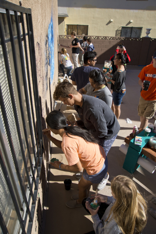 Students from Bishop Gorman High School work to paint a mural during a volunteer event held by the Gaels Give Hope organization, benefitting a New Genesis Transitional Housing apartment complex in ...