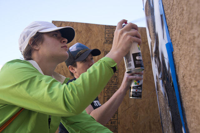 Stefania Ingramo, left, and Lora Feeoly work to paint a mural during a volunteer event held by the Gaels Give Hope organization from Bishop Gorman High School, benefitting a New Genesis Transition ...