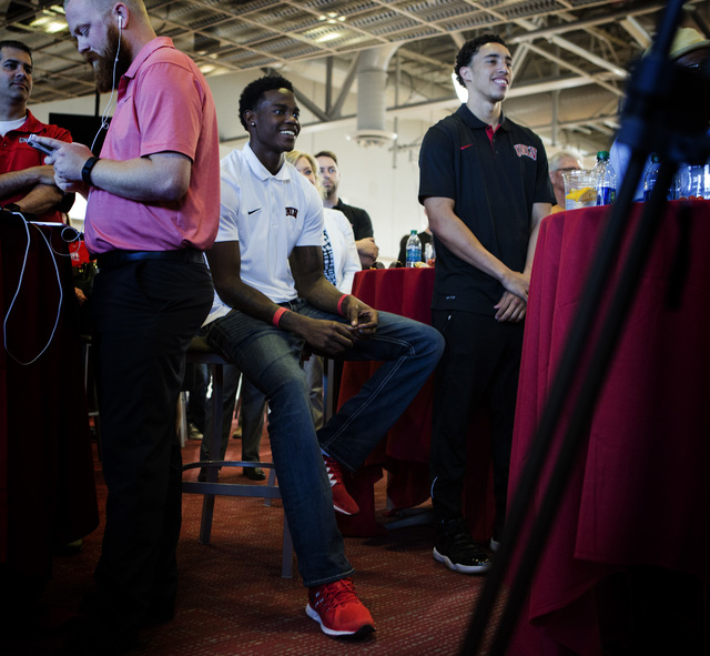 UNLV men's basketball players Dwayne Morgan, center, and Austin Starr,right, smile while new UNLV men's basketball coach Marvin Menzies speaks during a press conference at Mendenhall Center on Fri ...