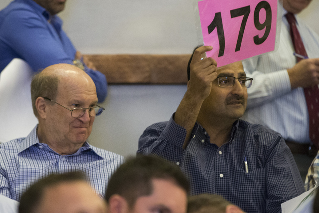 Manny Pattni, vice president of Lewis Management Corp., places a bid during a Bureau of Land Management land auction at the Clark County Commission chambers on Tuesday, April 26, 2016, in Las Vega ...