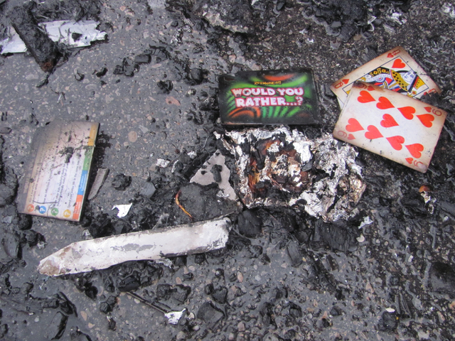 Playing cards and ashes sit in the parking lot following a fire at the Storage at Summerlin business on West Lake Mead Boulevard on Saturday, April 9, 2016. The fire damaged or destroyed 37 boats, ...
