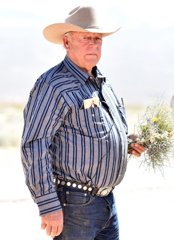 Rancher Cliven Bundy carries a bouquet of desert foliage that his cattle grazes on during an event near his ranch in Bunkerville on Saturday, April 11, 2015.  Bundy is hosting the event celebratin ...