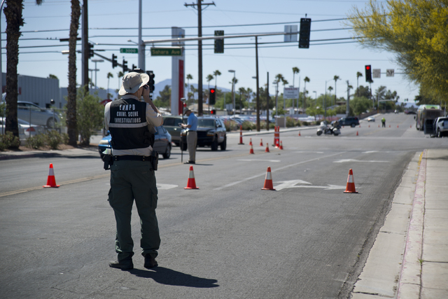 A crime scene investigator takes photos at the scene where an RTC bus and a pickup truck collided at the corner of Sahara Avenue and McLeod Drive in Las Vegas Sunday, April 17, 2016. Daniel Clark/ ...