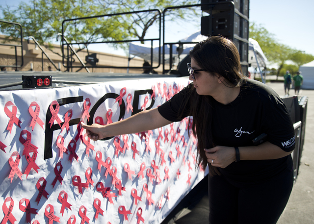 Ama Sanchez places a red ribbon onto a banner during the 26th annual Aid for AIDS of Nevada (AFAN) AIDS Walk Las Vegas at Town Square in Las Vegas on Sunday, April 17, 2016. (Daniel Clark/Las Vega ...