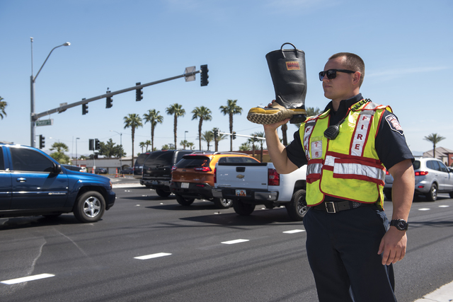 Probation firefighter Collin Wick, greets motorists to collect donations for the annual "Fill the Boot" drive that benefits the Muscular Dystrophy Association (MDA) at the corner ...
