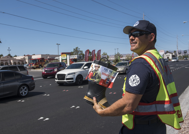 Fire Engineer Kurt Bacca, greets motorists to collect donations for the annual "Fill the Boot" drive that benefits the Muscular Dystrophy Association (MDA) at the corner or Sahar ...
