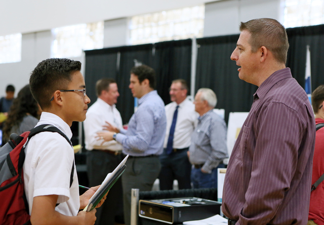 Hunter Espaniola, left, visits with Stimulus Technologies' system engineer Kaid Whipple at an information technologies booth during the Integrating Career Academies by Networking Business and Educ ...