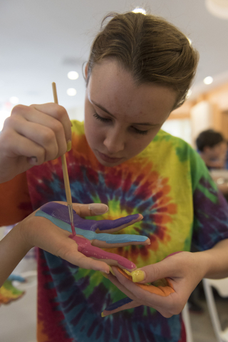15-year-old Saylor Helms paints 16-year-old Caroline Cohen's hand during a collaborative art project, at Yiddish Las Vegas: A Music & Culture Festival at Temple Sinai in Las Vegas Sunday, Apri ...
