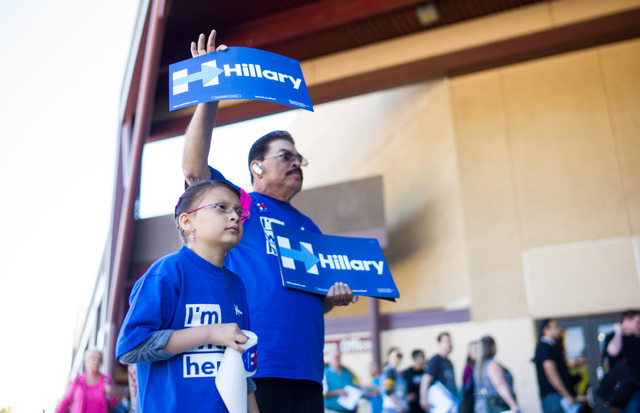 Jose Mejia and daughter Kayla, 7, hand out signs and stickers to supporters of Democratic presidential candidate Hillary Clinton at the Clark County Democratic Party Convention at Cashman Center i ...