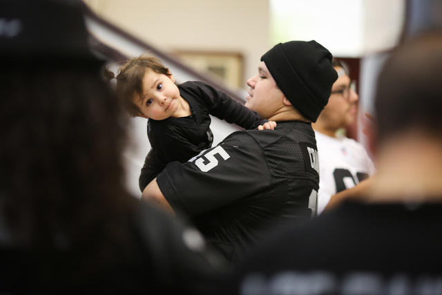 Delfina Rubi IV, 24, holds his 2-year-old daughter Penelope Rubi while waiting for Oakland Raiders owner Mark Davis during a Southern Nevada Tourism Infrastructure Committee meeting at UNLV in Las ...