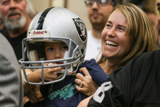 Cheri Branca, of Las Vegas, holds up her four-year-old Levi Branca up while meeting Mark Davis during a Southern Nevada Tourism Infrastructure Committee meeting at UNLV in Las Vegas on Thursday, A ...