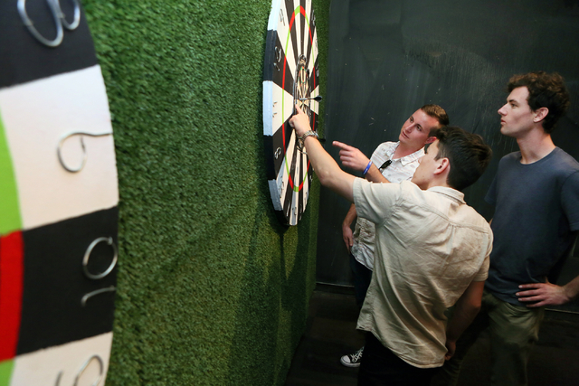 Brandon DeLaroche, front center, Ryan Viggiano, back left, and Bo Wolfe tally up points while playing darts at Gold Spike Tuesday, March 22, 2016, in Las Vegas. Gold Spike, with new design and own ...