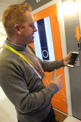 Doug Barnett, an exhibitor with Vivint Smart Home, demonstrates how the system works during 2016 CES. When the doorbell rings, people get a text message notification on their phone. Michael Lyle/V ...