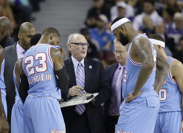 In this photo taken Saturday April 9, 2016, Sacramento Kings coach George Karl, center, huddles with team members Ben McLemore, left, and DeMarcus Cousins, right, during the second half of an NBA ...