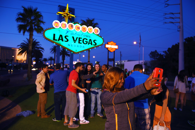 Tourists take photos as the Welcome to Fabulous Las Vegas sign on the Strip is colored green Tuesday, March 15, 2016. Southern Nevada’s saw a 2.9 percent increase in visitors for March, the Las  ...