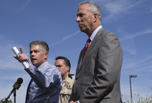 Metro homicide Lt. Dan McGrath, left, with Clark Country District Attorney Steven Wolfson, right, answers questions at the site of fatal shooting of store employee Matthew Christensen, 24, that to ...