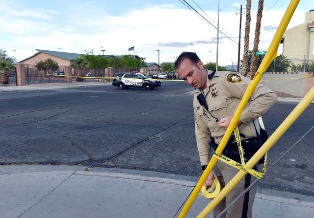 A Las Vegas police officer secures the area with police tape Friday, April 8, 2016, in Las Vegas. Police have blocked off access in and around the North East Area Command station as they deal with ...