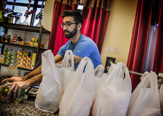 Haidar Karouni, checks out groceries while working at the his family's Afandi Restaurant, 5181 W. Charleston Blvd. on Friday, Nov. 13, 2015. Karouni is waiting for is U.S. citizenship to be approv ...