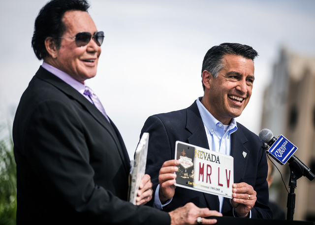 Nevada Gov. Brian Sandoval, right, presents a license plate to entertainer Wayne Newton during the groundbreaking for Project Neon near The Smith Center for the Performing Arts in Las Vegas on Thu ...