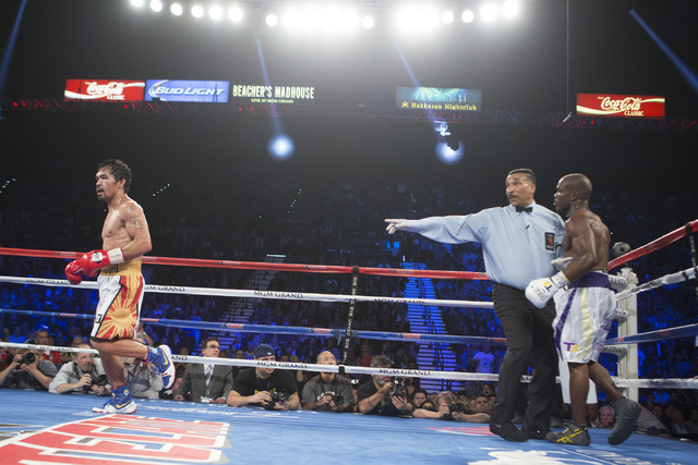 Manny Pacquiao, left, walks to his corner after knocking down Timothy Bradley in the seventh round of the WBO International welterweight championship boxing bout at the MGM Grand Garden ArenaSatur ...