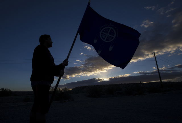 Kota Lavalle holds the Shivwits Band of Paiutes flag before the start of the Gold Butte Culture Walk, Saturday, April 23, 2016, in Gold Butte, Nevada. The fourth annual event is aimed at promoting ...
