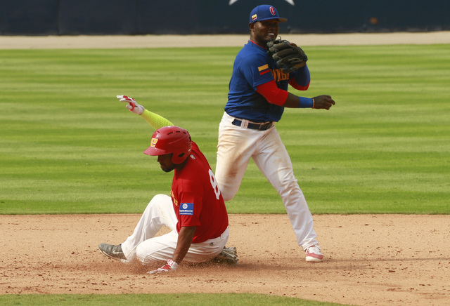 Spain's Oscar Angulo, left, is tagged out by Colombia's second baseman Dilson Herrera during the World Baseball Classic qualifying match in Panama City, Thursday, March 17, 2016. Colombia won 9-2. ...