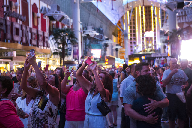 People watch as a tribute to Prince, who passed away at age 57, is shown at Fremont Street Experience in Las Vegas on Thursday, April 21, 2016. (Chase Stevens/Las Vegas Review-Journal) Follow @css ...