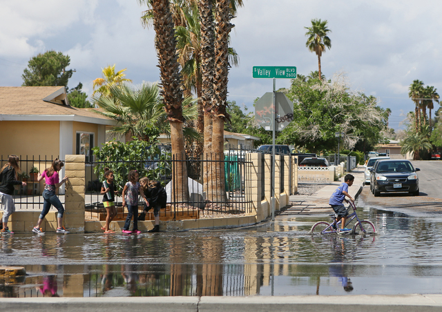Children make their way through and play along a flooded area of Valley View Boulevard near San Angelo Avenue Saturday, April 9, 2016, in Las Vegas. (Ronda Churchill/Las Vegas Review-Journal)