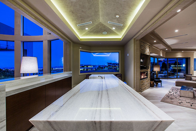 A large white bar sits between the living room and the gourmet kitchen and great room. (Courtesy Shapiro & Sher Group)