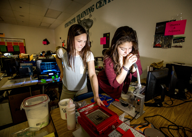 Silvestri Junior High School students Abby Blumberg, left, and Angie Sanchez, press plastic golf tees during class on Tuesday, March 29, 2016. The school recently received a $14.1 million grant to ...