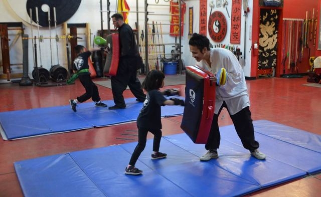 Alicia Young, 5, works with Alex Baginski as her brother Ethan works in the background with instructor Christopher Nason in a children's class at the Lohan School of Shaolin, 3850 Schiff Drive. Gi ...