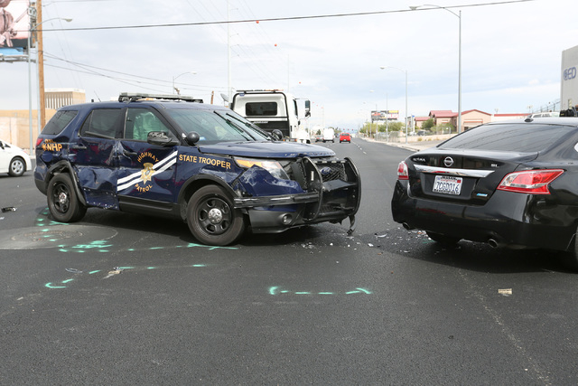 Police work to clean up a crash involving a Jeep Cherokee that allegedly pulled out in front of a Nevada Highway Patrol trooper in Las Vegas on Friday, April 8, 2016. Brett Le Blanc/Las Vegas Revi ...