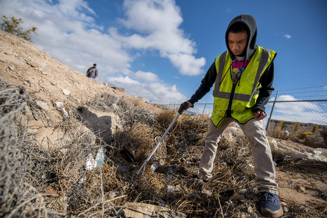 Naphon Meesiri picks up garbage during the cleanup of the newly acquired UNLV site off of Tropicana Avenue east of Koval Lane in Las Vegas on Saturday, April 9, 2016. More than 150 volunteers regi ...