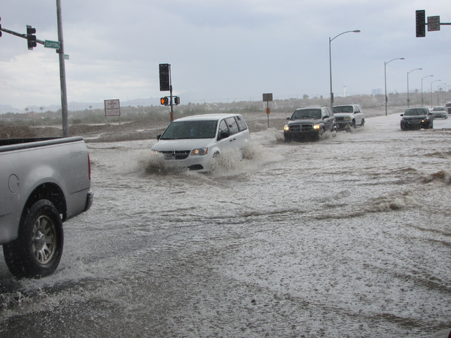 Vehicles slow down to navigate high water at the intersection of Lone Mountain Road and Clayton Street in North Las Vegas on Saturday, April 9, 2016. Greg Haas/Las Vegas Review-Journal Follow @RJg ...