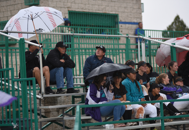 Spectators brave the rain as they watch a baseball game played between Green Valley and Silverado played at Green Valley's Fairless Field in Henderson on Saturday, April 9, 2015. Silverado defeate ...
