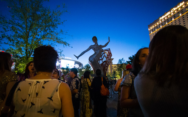 People gather for the lighting ceremony for the 40-foot tall Bliss Dance sculpture at The Park, outside of the T-Mobile Arena and New York New York hotel-casino in Las Vegas on Monday, April 6, 20 ...
