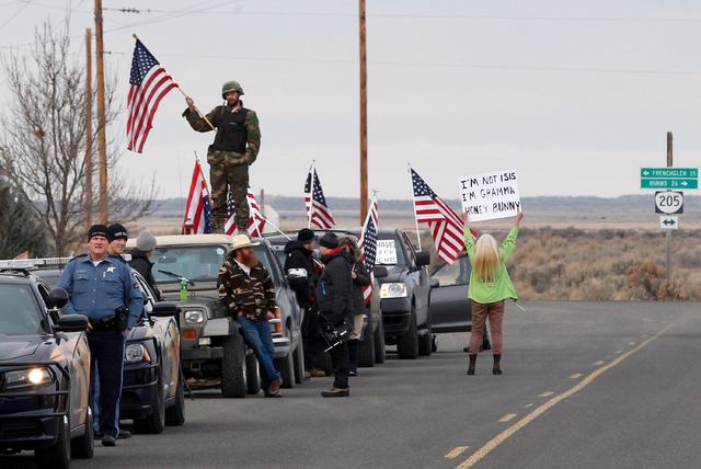 In this Feb. 11, 2016 file photo, authorities and demonstrators wait at the Narrows roadblock near the Malheur National Wildlife Refuge near Burns, Ore. Dozens of armed occupiers who took over a n ...