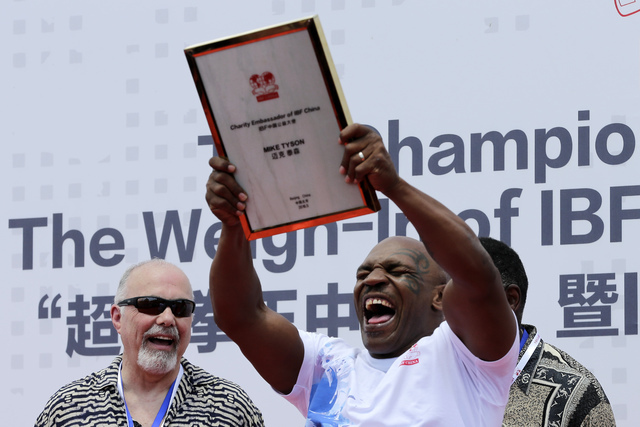 Former heavyweight boxing champion Mike Tyson reacts as he is awarded the charity ambassador of IBF China during the weigh-in ceremony of the 2016 IBF World Championship Bout at the Mutianyu secti ...
